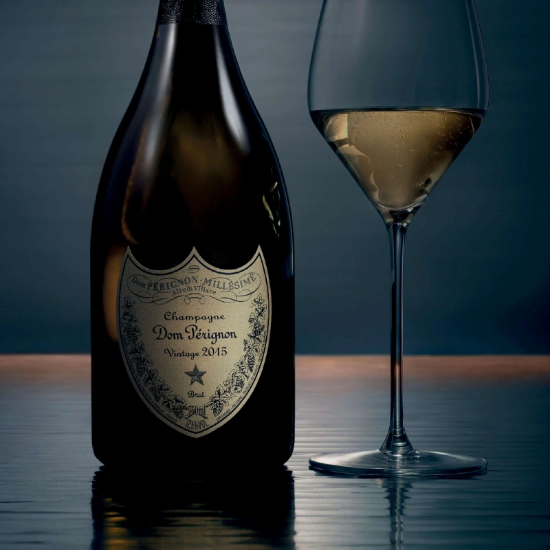 Dom Pérignon Vintage 2015 fles naast gevuld champagneglas